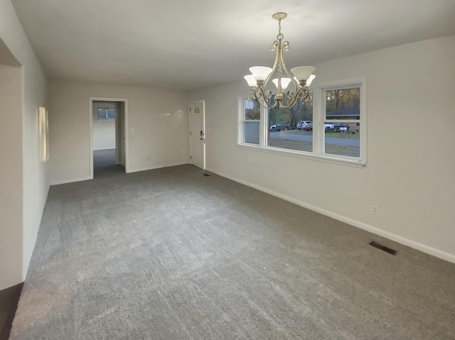 carpeted empty room featuring a notable chandelier