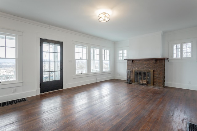 unfurnished living room with ornamental molding, dark wood-type flooring, and a brick fireplace