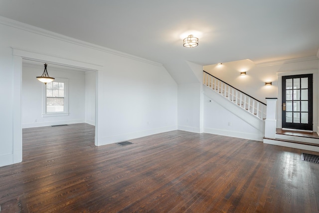 unfurnished living room with dark hardwood / wood-style flooring, vaulted ceiling, and ornamental molding