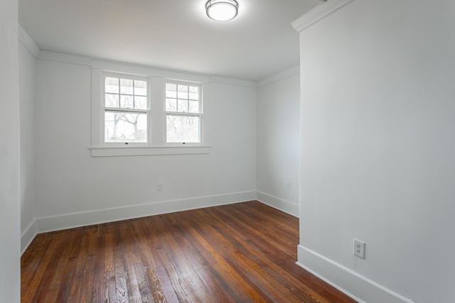 spare room featuring dark wood-type flooring and ornamental molding