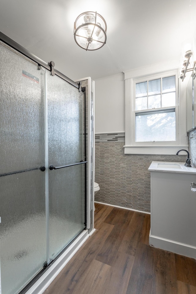 bathroom featuring hardwood / wood-style flooring, vanity, toilet, and a shower with shower door