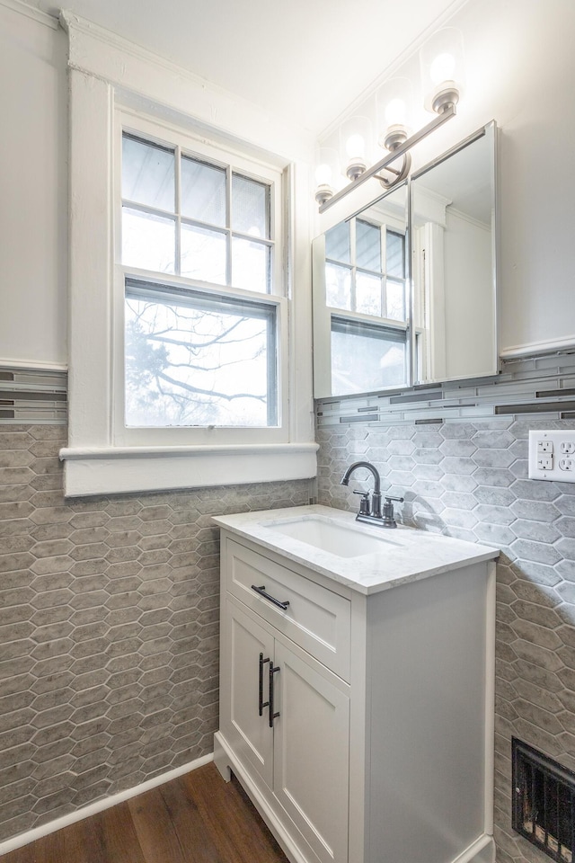 bathroom featuring vanity, wood-type flooring, and tile walls