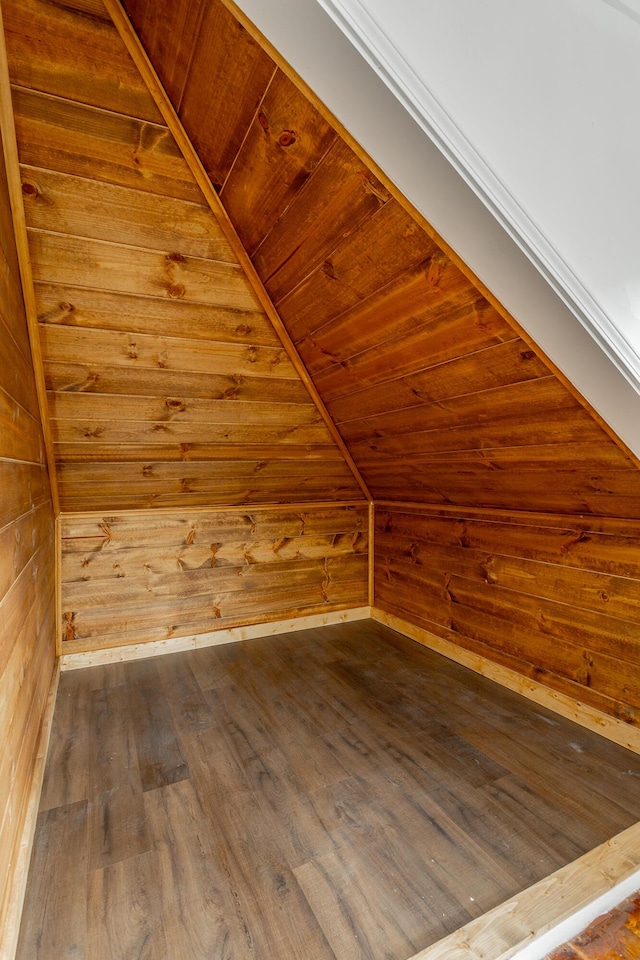 additional living space with wood walls, wood-type flooring, and wood ceiling