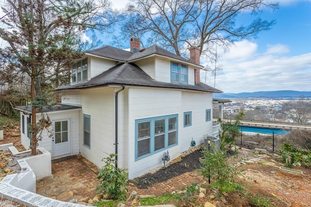 view of side of home with central air condition unit and a mountain view