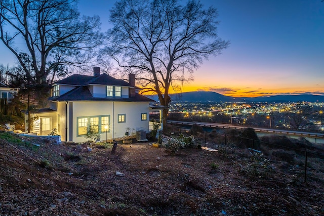 back house at dusk featuring a mountain view, french doors, and cooling unit