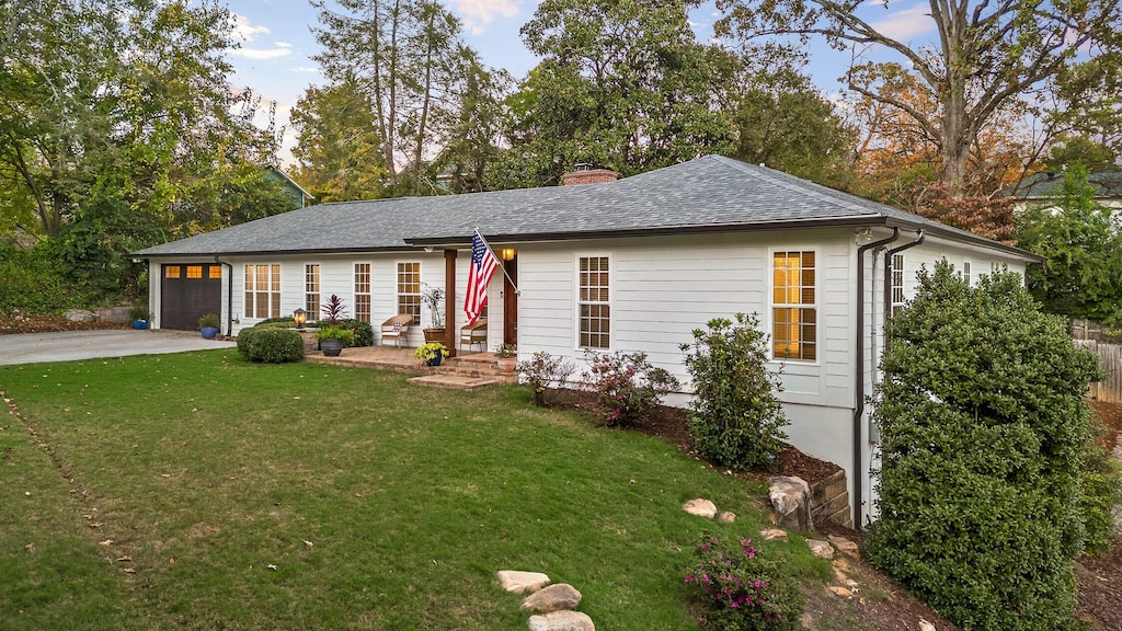 single story home featuring a lawn and a garage