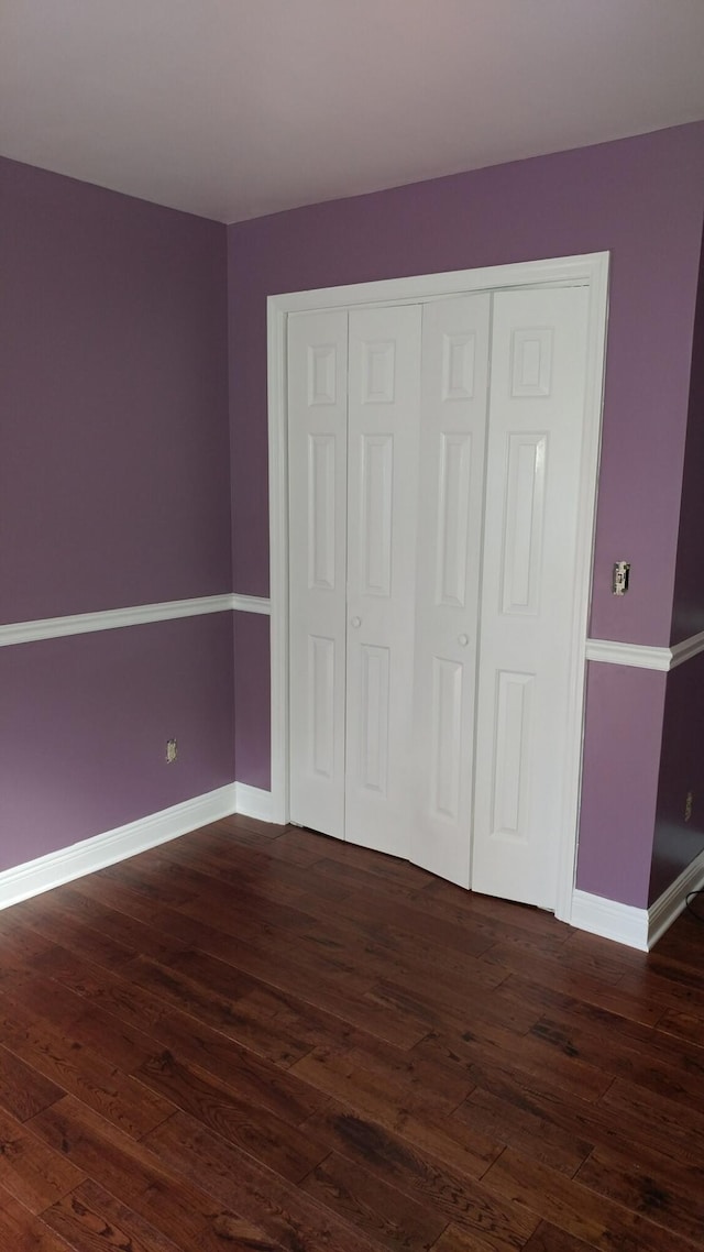 unfurnished bedroom with dark wood-type flooring