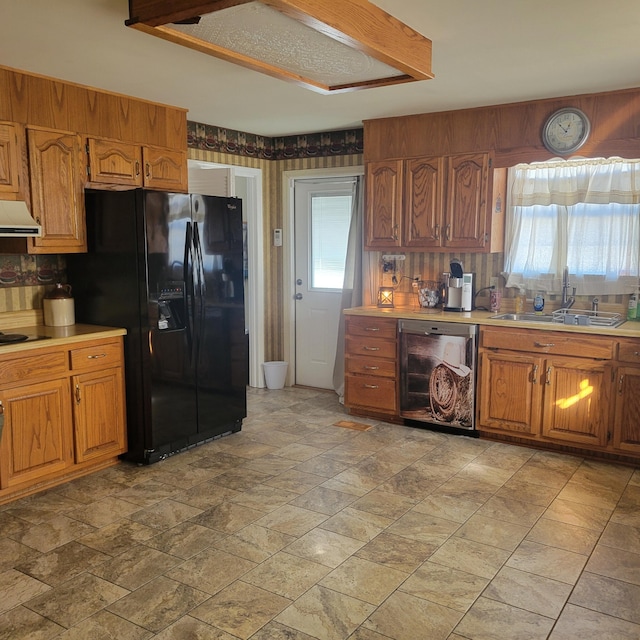 kitchen featuring a healthy amount of sunlight, black fridge with ice dispenser, sink, and beverage cooler