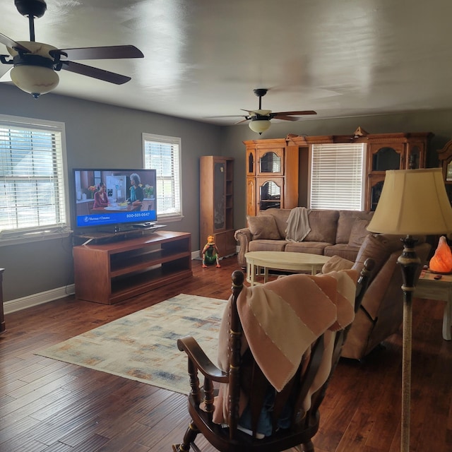 living room featuring ceiling fan, a healthy amount of sunlight, and dark hardwood / wood-style flooring