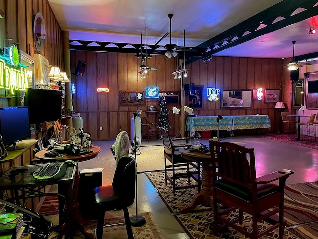 dining room featuring ceiling fan and wood walls