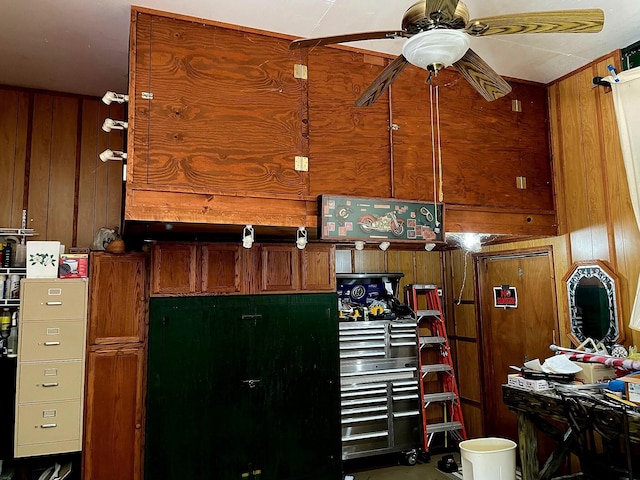 kitchen featuring ceiling fan and wooden walls