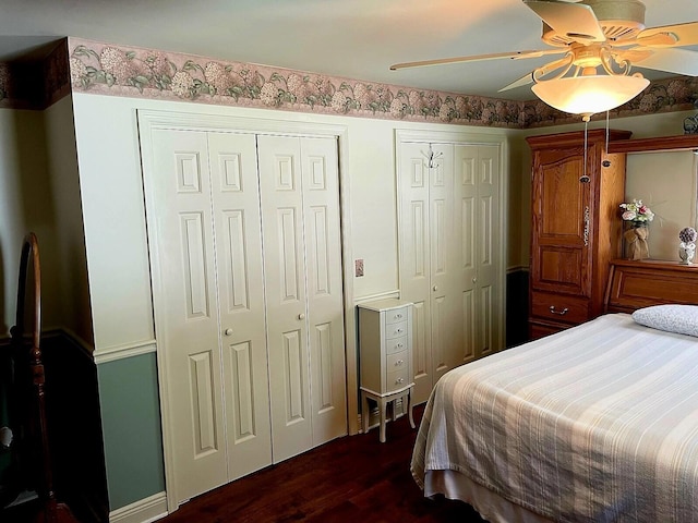 bedroom featuring ceiling fan, dark hardwood / wood-style flooring, and multiple closets