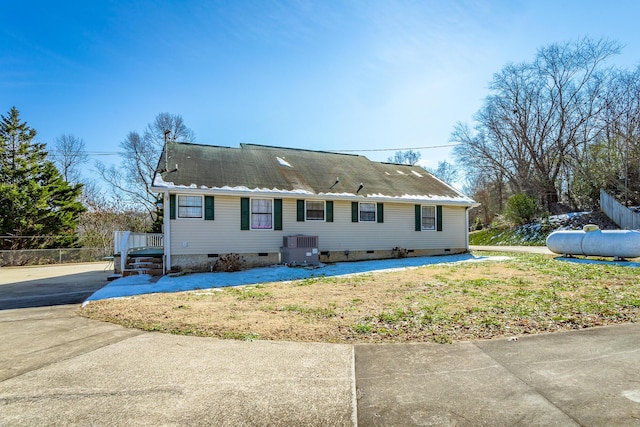 view of front of home with a front lawn and central air condition unit