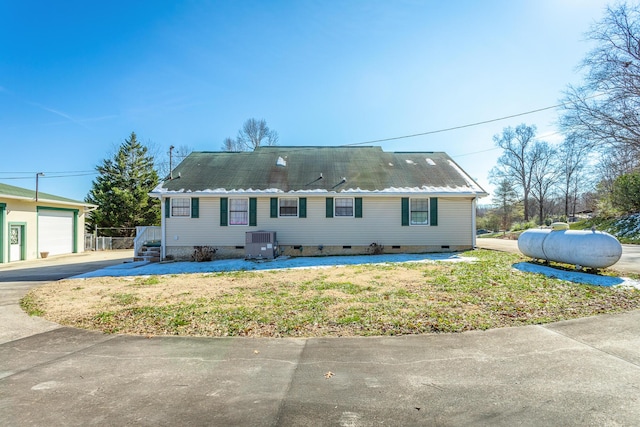 view of front of property with central AC unit, a front yard, and a garage