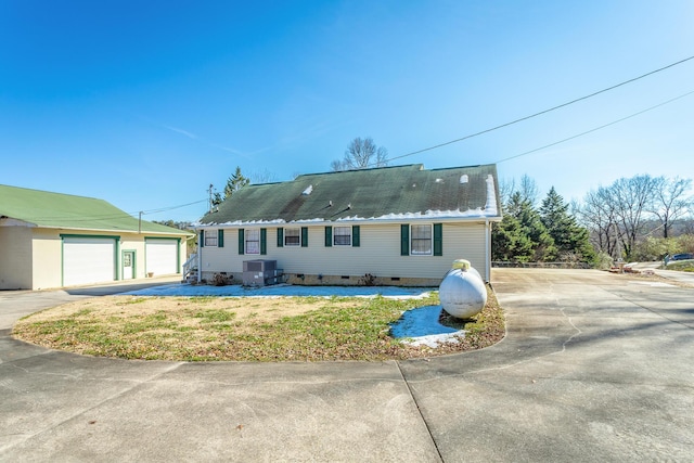 view of front of property featuring a garage and central AC unit