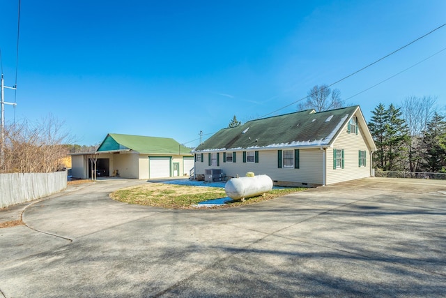 back of house with a garage and central air condition unit