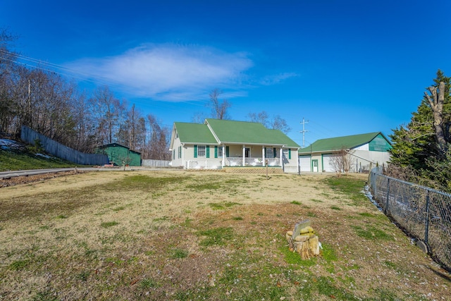 rear view of house featuring covered porch and a yard