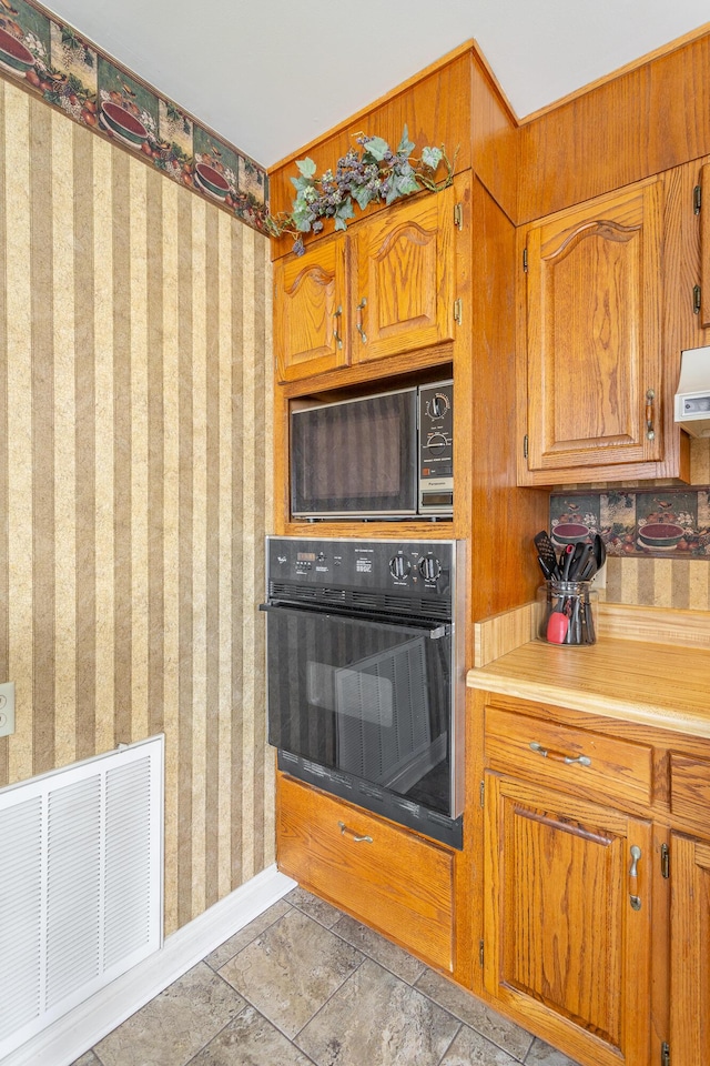 kitchen featuring black appliances and exhaust hood