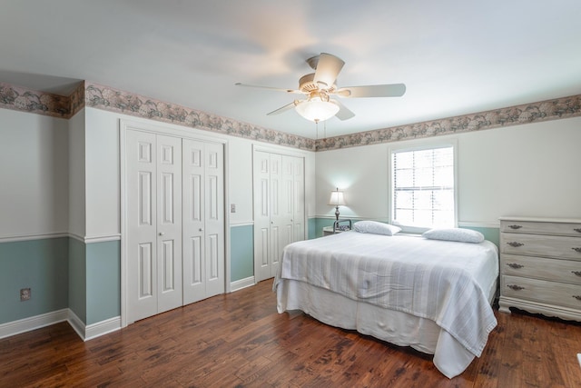 bedroom featuring ceiling fan, dark wood-type flooring, and two closets