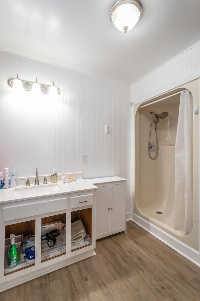 bathroom featuring vanity, wood-type flooring, and walk in shower