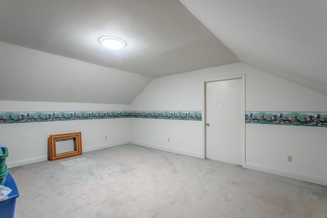 additional living space with light carpet and vaulted ceiling