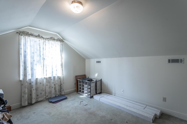 additional living space featuring lofted ceiling and light carpet