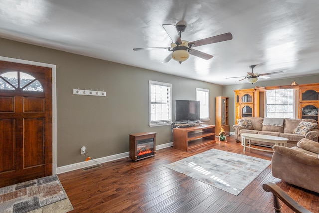 living room with dark wood-type flooring, a healthy amount of sunlight, and ceiling fan