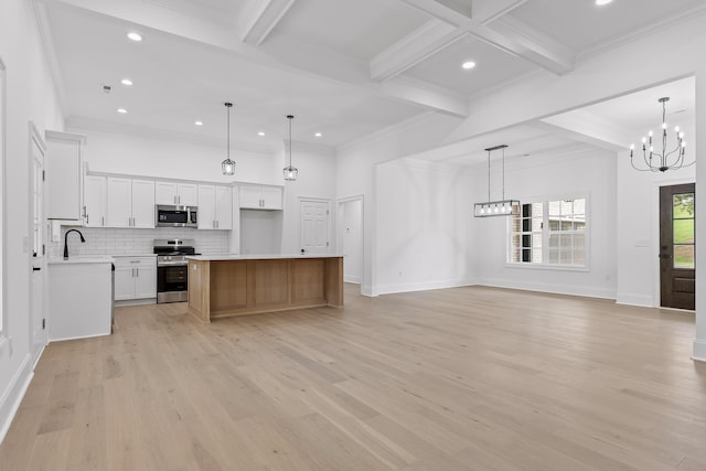 kitchen featuring a center island, hanging light fixtures, stainless steel appliances, beamed ceiling, and white cabinets