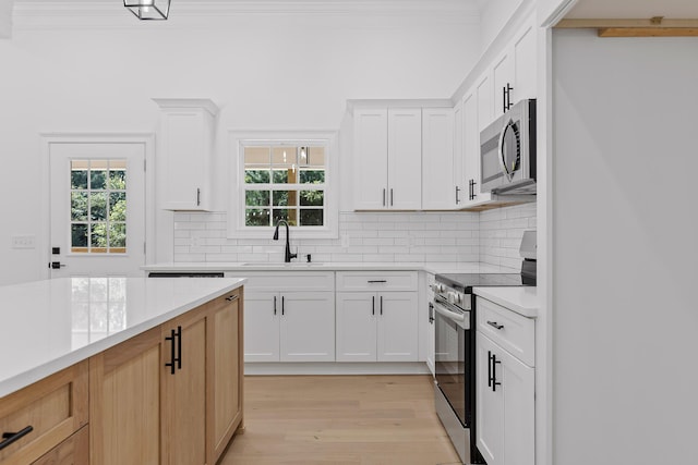 kitchen with stainless steel appliances, white cabinetry, and sink