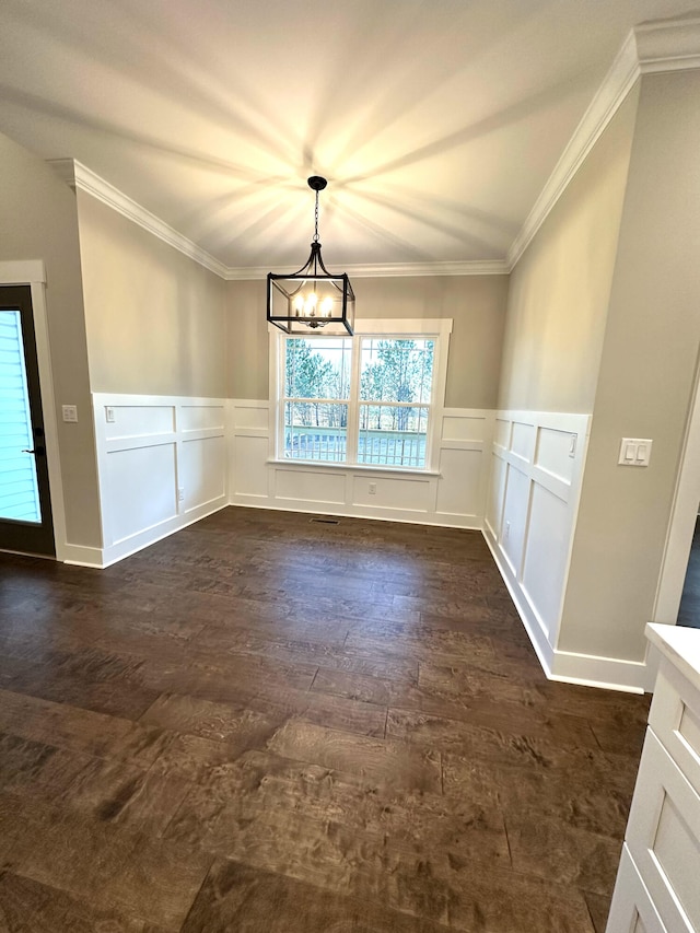 unfurnished dining area featuring crown molding and an inviting chandelier