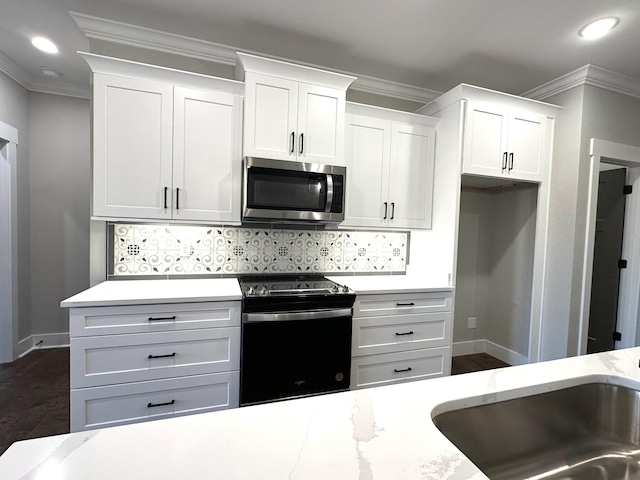 kitchen featuring black electric range oven, backsplash, white cabinets, sink, and ornamental molding