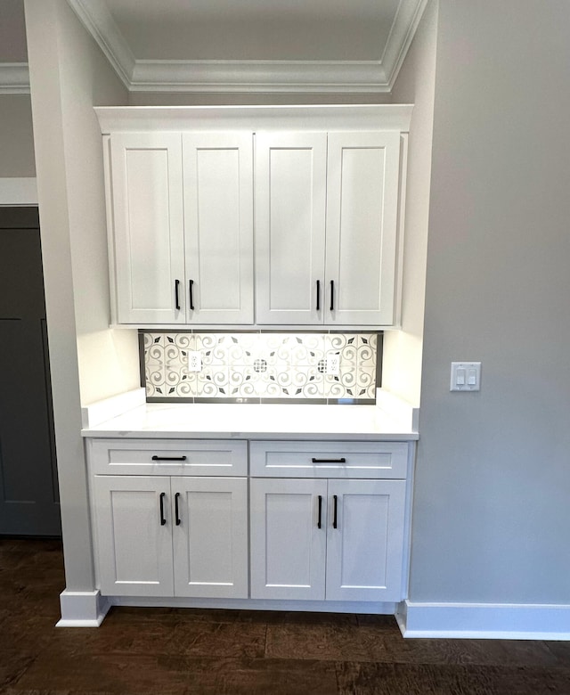 bar featuring decorative backsplash, crown molding, white cabinets, and dark wood-type flooring