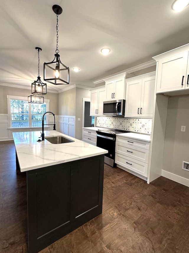 kitchen with white cabinetry, sink, hanging light fixtures, a kitchen island with sink, and appliances with stainless steel finishes