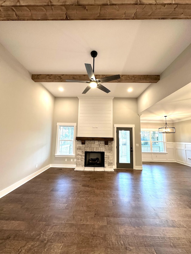 unfurnished living room with beam ceiling, a wealth of natural light, and ceiling fan