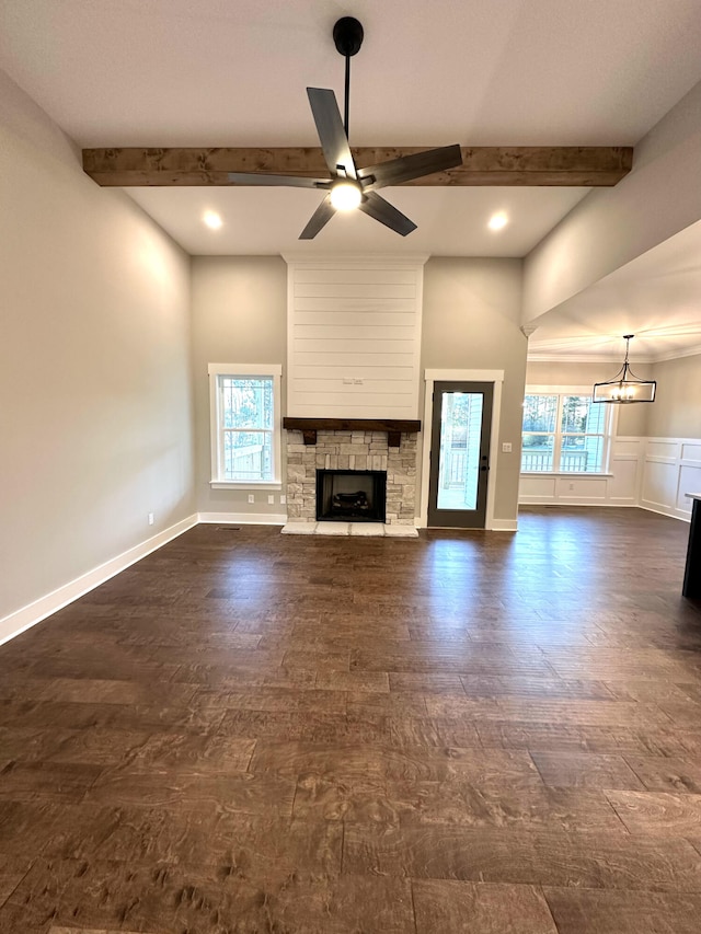 unfurnished living room featuring beamed ceiling, a stone fireplace, ceiling fan, and dark wood-type flooring