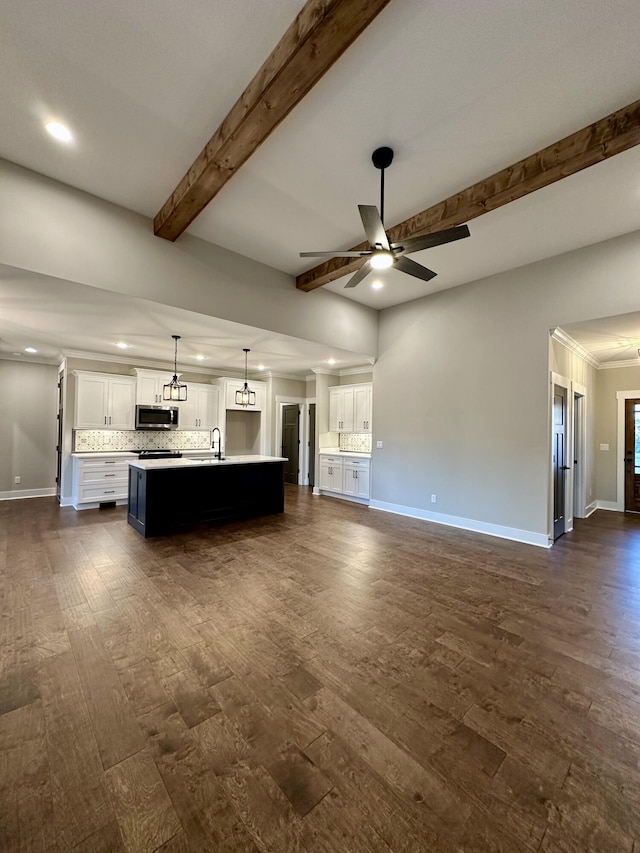 unfurnished living room featuring beam ceiling, dark hardwood / wood-style flooring, ceiling fan, and sink