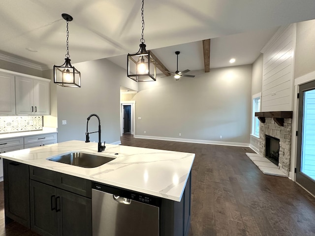 kitchen featuring beam ceiling, ceiling fan, dishwasher, sink, and a center island with sink