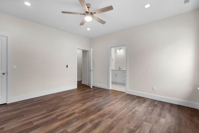 unfurnished bedroom with ensuite bathroom, sink, ceiling fan, and dark wood-type flooring