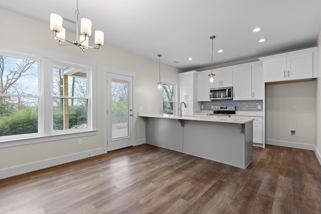 kitchen featuring white cabinets, decorative light fixtures, stainless steel appliances, and a chandelier