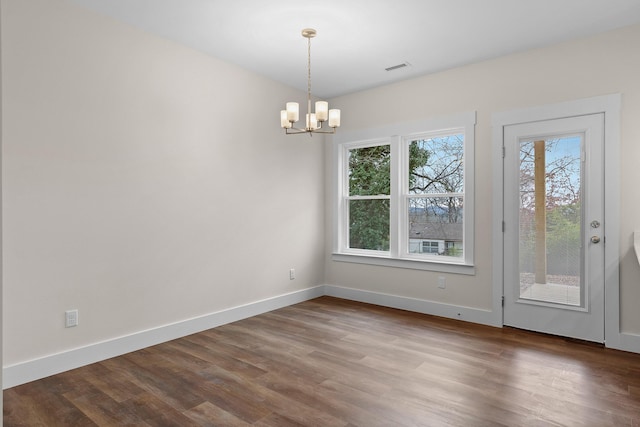 unfurnished dining area featuring a chandelier and hardwood / wood-style flooring