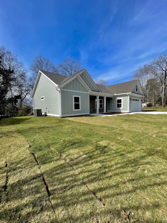 view of front facade with board and batten siding, a front yard, central air condition unit, and a garage