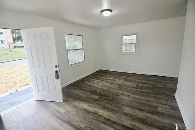 unfurnished room with dark hardwood / wood-style floors and a wealth of natural light