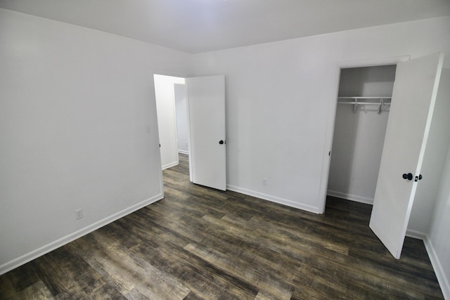 unfurnished bedroom with a closet and dark wood-type flooring