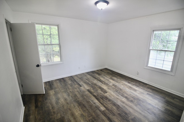 unfurnished room with dark hardwood / wood-style floors and a wealth of natural light