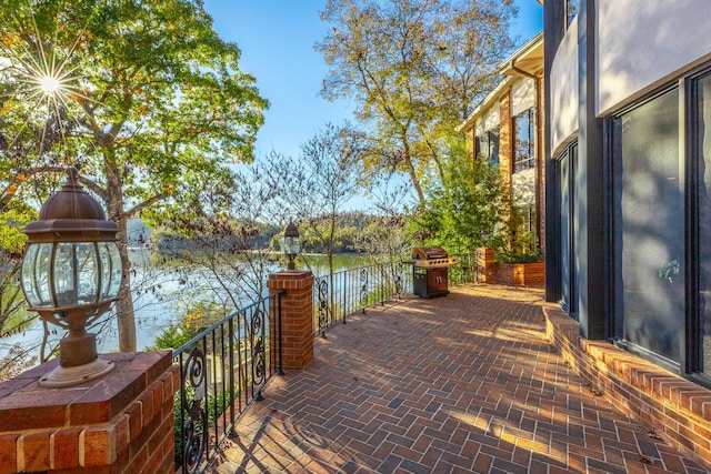 view of patio featuring a water view and area for grilling