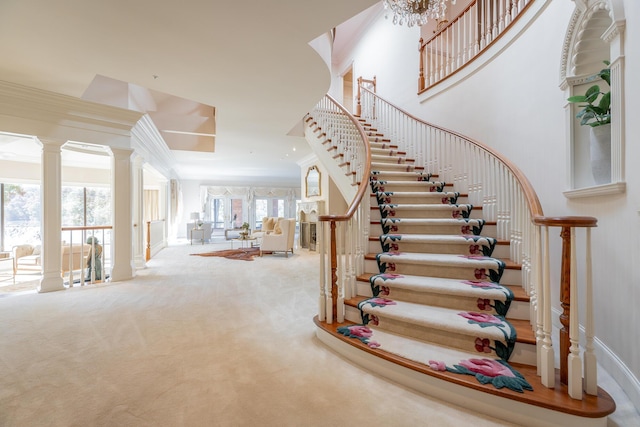 stairway featuring carpet flooring, crown molding, and a notable chandelier