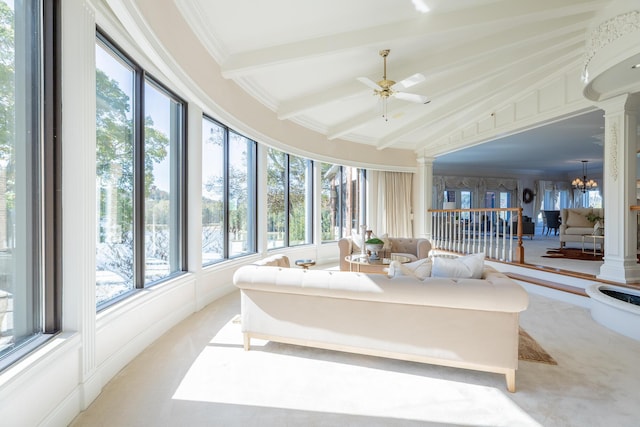 sunroom featuring vaulted ceiling with beams, ceiling fan with notable chandelier, and ornate columns