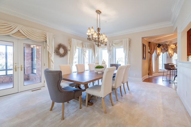 carpeted dining area with crown molding, french doors, and plenty of natural light