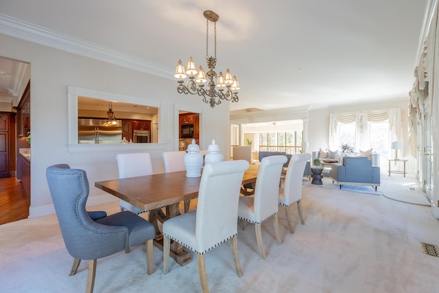 dining room with light colored carpet, ornamental molding, and a chandelier