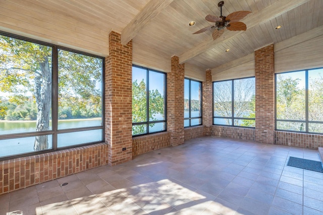 unfurnished sunroom with a wealth of natural light, ceiling fan, a water view, wooden ceiling, and vaulted ceiling with beams